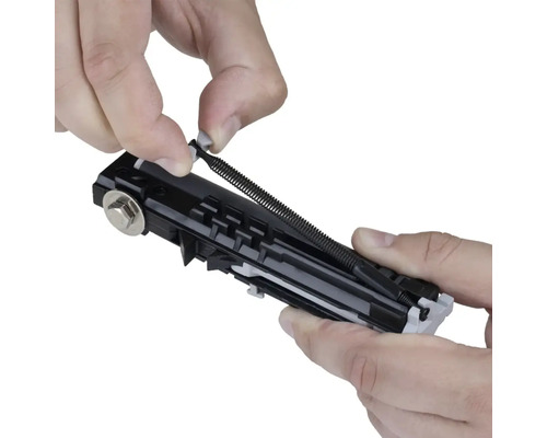 Detailní záběr osoby vkládající tažnou pružinu do rolety.