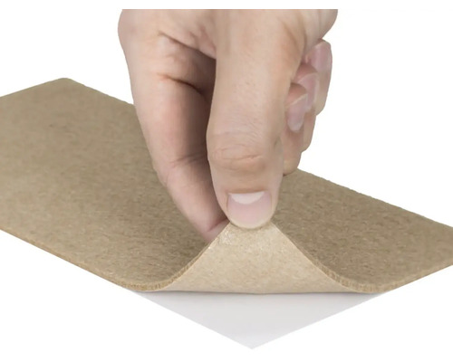 Ruka zvedá plstěnou podložku.