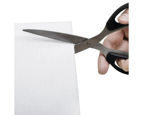 Ruka stříhá list nůžkami.