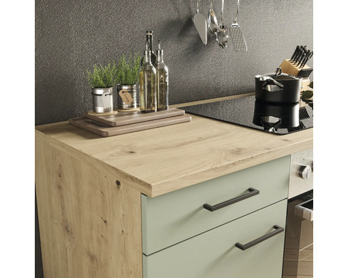 Kuchyňská scéna s pracovní deskou, dřezem, varnou deskou, hrncem a kuchyňským náčiním.