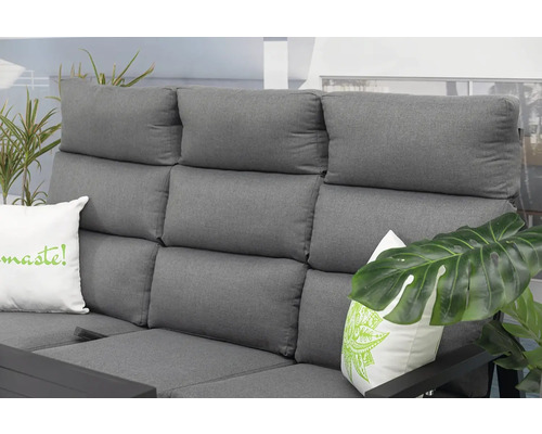 Detail šedé venkovní pohovky s polštáři a rostlinami