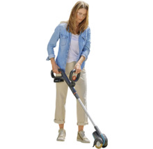 Žena používá akumulátorový čistič spár na zahradě.