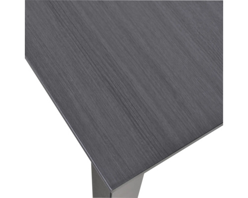 Detailní pohled na desku stolu s dřevěnou strukturou a nohou stolu