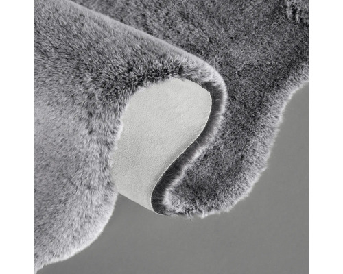 Šedý koberec s chlupatou texturou a zadní stranou
