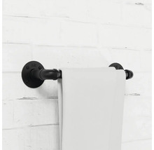 Držák na ručníky z kovové trubky s ručníkem na cihlové zdi