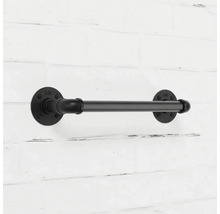 Černý kovový držák toaletního papíru v industriálním stylu na cihlové zdi