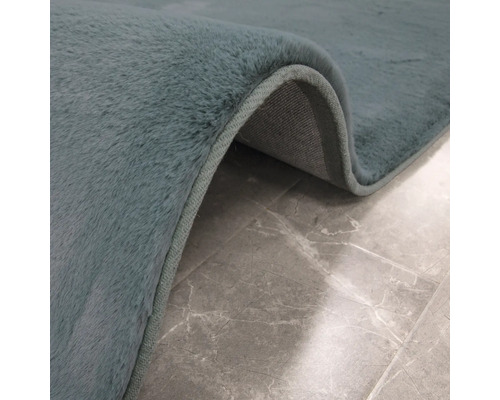 Detail koberce s vlasem na dlážděné podlaze.