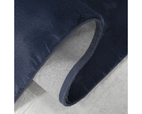 Detailní pohled na tmavě modrý koberec s textilním podkladem