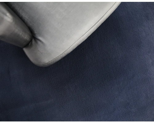 Detail šedého čalouněného nábytku na tmavém pozadí