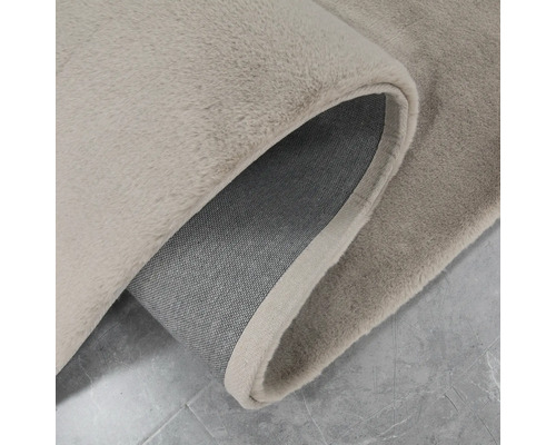 Detail béžového koberce se zkrouceným okrajem