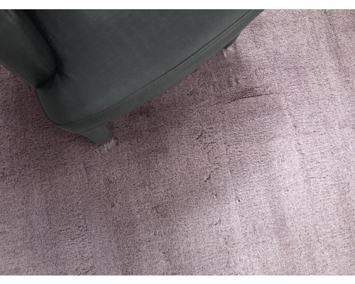 Detail fialového koberce s částí křesla