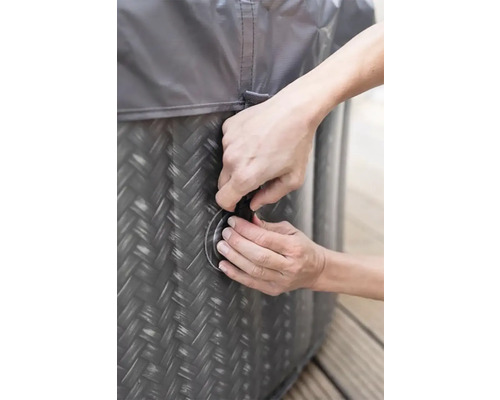 Detailní záběr osoby zavírající nafukovací vířivku s krytem