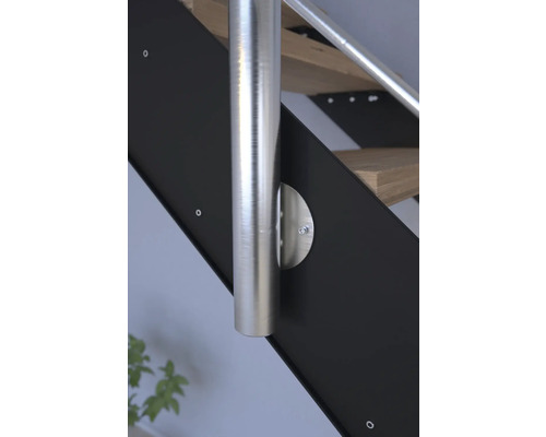 Detail schodiště s nerezovým zábradlím a černými bočními panely.