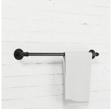 Držák na ručníky z kovové trubky s ručníkem na cihlové zdi