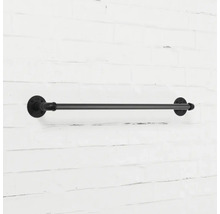 Černý kovový držák na ručníky na cihlové zdi