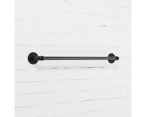 Černý kovový držák na ručníky na cihlové zdi