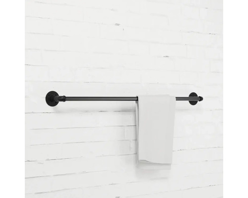 Černý držák na ručníky s ručníkem na zdi