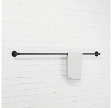 Černý držák na ručníky s ručníkem na bílé zdi