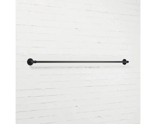 Černý kovový držák na ručníky na bílé zdi