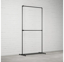 Stojan na šaty z trubek v industriálním designu před cihlovou zdí