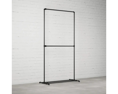 Stojan na šaty z trubek v industriálním designu před cihlovou zdí