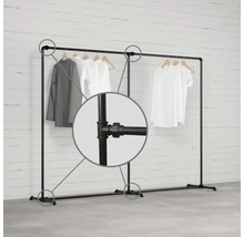 Věšák na oděvy z kovových trubek s oblečením na dřevěných ramínkách