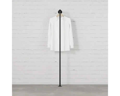 Stojan na oblečení se zavěšenou košilí před zdí