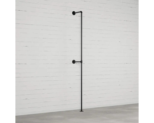 Černá tyč na šaty z trubek namontovaná na zdi