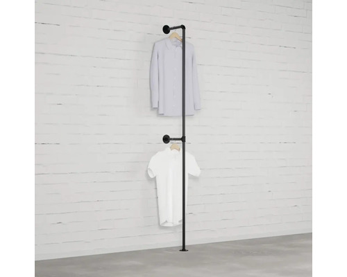 Volně stojící věšák na šaty z kovové trubky se dvěma košilemi na zdi