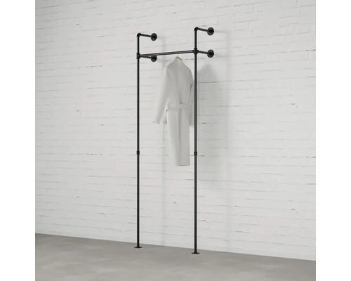 Volně stojící šatní tyč s županem před zdí