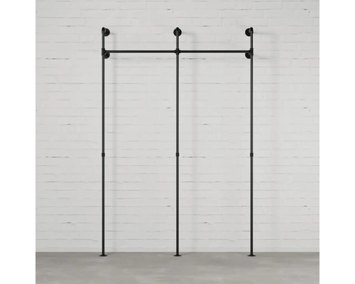 Černý modulární regálový systém před cihlovou zdí