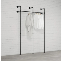 Černý věšák na oblečení s oblečením před cihlovou zdí