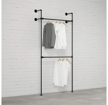 Černý dvoupodlažní věšák na oblečení s oblečením u zdi