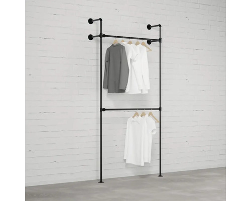 Černý dvoupodlažní věšák na oblečení s oblečením u zdi