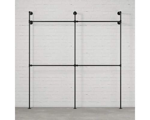 Volně stojící věšák na oblečení z kovových trubek před zdí