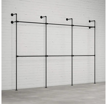 Černý ocelový trubkový šatní systém před cihlovou zdí