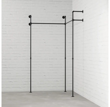 Věšák na oblečení z kovových trubek před stěnou