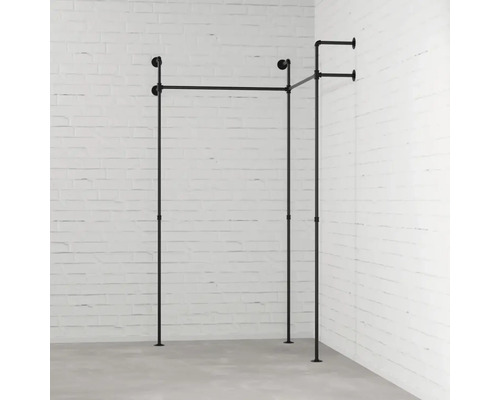 Věšák na oblečení z kovových trubek před stěnou