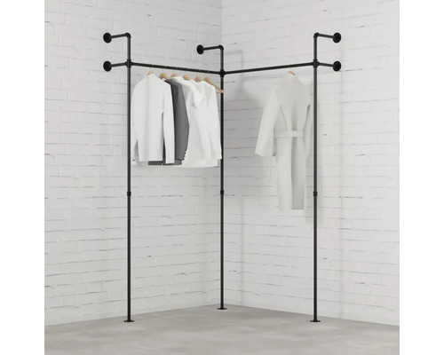 Rohový věšák na šaty z kovových trubek se zavěšeným oblečením