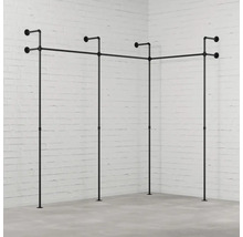 Věšák na šaty z trubek v rohovém pokoji před cihlovou zdí