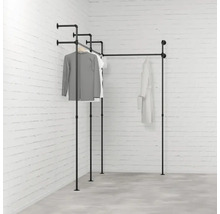 Černý kovový trubkový věšák na oblečení v rohovém pokoji s oblečením