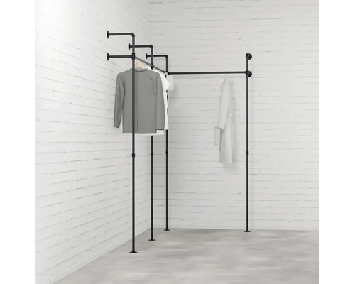 Černý kovový trubkový věšák na oblečení v rohovém pokoji s oblečením