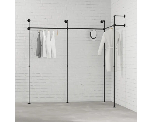 Černý šatní systém s oblečením před bílou cihlovou zdí