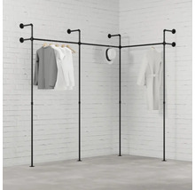 Rohový věšák na šaty z trubek s oblečením před cihlovou zdí