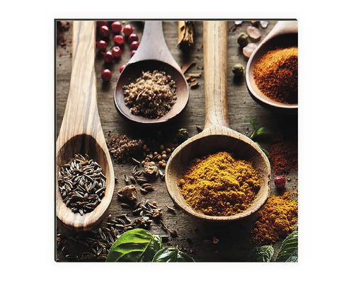 Dekorativní nástěnná malba s různým kořením v dřevěných lžících na stole.