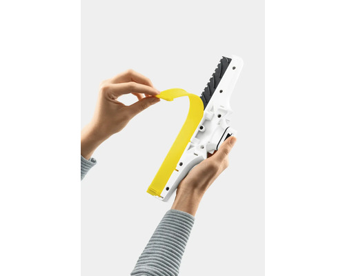 Osoba vyměňuje gumovou stěrku okenního vysavače.