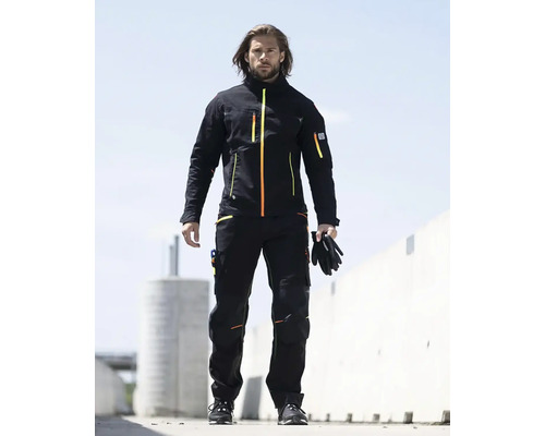 Muž má na sobě pracovní oděv skládající se z bundy a kalhot