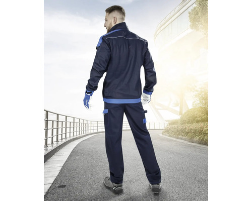 Muž zezadu v tmavě modré pracovní bundě a pracovních kalhotách