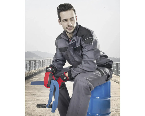 Muž má na sobě pracovní oděv skládající se z bundy a kalhot a rukavic.