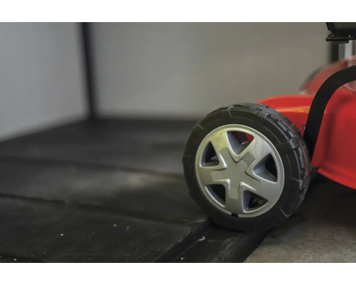 Detailní záběr kola sekačky na trávu.